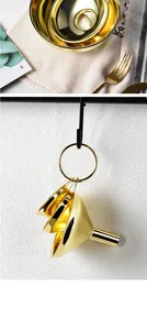 Detailed shot of three golden stainless steel funnels set hanging on a black hook