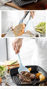 Close-up of light blue silicone tongs and wooden handle spatula in use during cooking