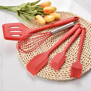 5-piece red silicone baking tool set including whisk, spatula, and oil brush on mat