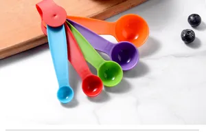 Gros plan d'un ensemble de cuillères à mesurer colorées en plastique sur marbre