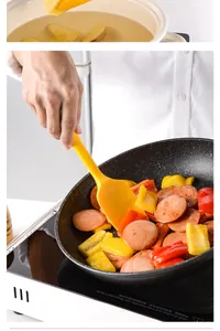 Detailed shot of yellow silicone spatula stir-frying sausages and peppers in black pan