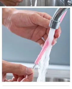 Detail showing a pink reusable silicone straw being cleaned with a brush under running water