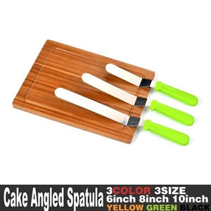 Set of three stainless steel icing spatulas with green handles shown on a wooden board