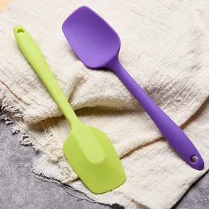 Set of two colorful food-grade silicone spatulas for professional cake baking and scraping.