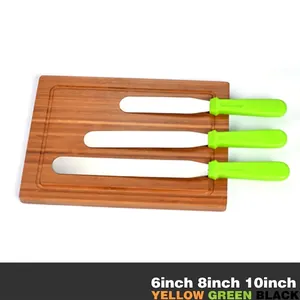 Set aus drei Tortenmessern aus Edelstahl mit grünen Griffen auf Holzbrett