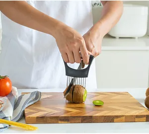 Detalle de un soporte profesional de acero inox cortando kiwi en tabla de madera