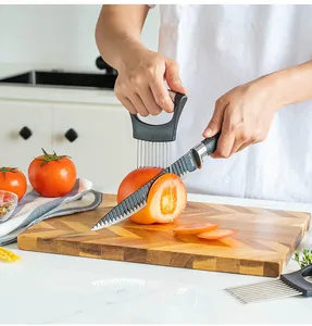 Vista detallada de un soporte para cebollas cortando un tomate sobre una tabla madera