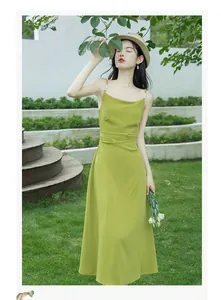 Elegant French style green slip dress with pearl straps shown in a beautiful garden setting