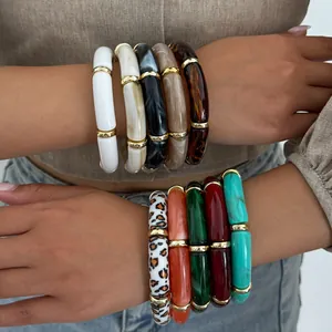 Nahaufnahme von geschichteten Acryl-Armbändern mit Retro-Leoparden- und Marmormustern