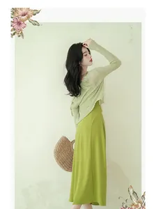 Side view of an elegant green French-style camisole dress with a light knit top.
