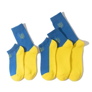 Detail shot of blue and yellow cotton socks featuring the Ukrainian trident emblem