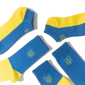 Detailed view of blue and yellow socks featuring Ukrainian national coat of arms embroidery