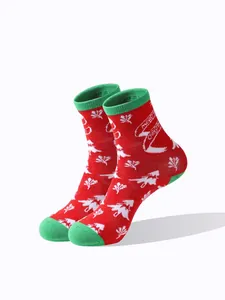 Detailaufnahme von roten Weihnachts-Wadenstrümpfen mit Baum- und Schneeflockenmuster