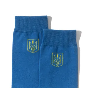 Close-up of blue knitted socks featuring the yellow Ukrainian trident emblem detail.