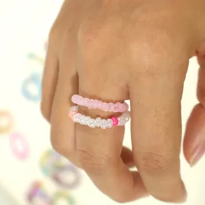 Set of handmade colorful bohemian style beaded rings displayed on a female finger