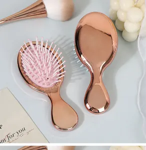 Detail of mini rose gold electroplated air cushion hairbrush for travel and massage