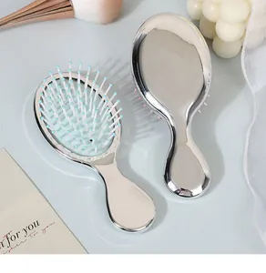 Close-up of portable mini silver electroplated air cushion massage hairbrush for travel
