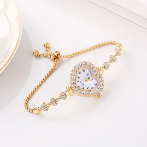 Primo piano di un orologio a bracciale dorato a cuore con dettagli in strass