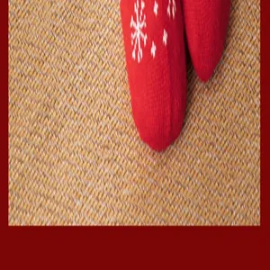 Macro detail of red knitted floor socks with white snowflake pattern on a textured mat