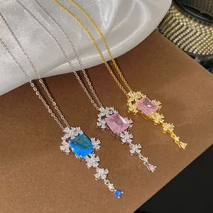 Detailweergave van bloemige halskettingen met blauwe en roze edelstenen in zilver en goud