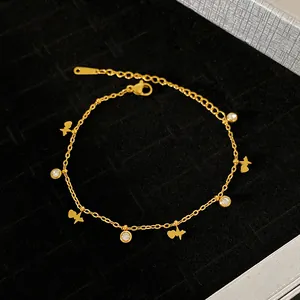 Detailed close-up view of a gold titanium steel bracelet with heart and crystal charms