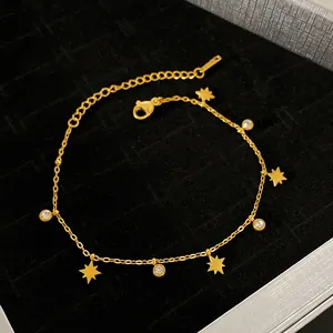 Close-up of titanium steel bracelet with 18K gold plated stars and crystal charms