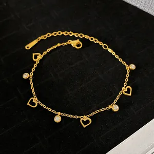 Macro view of a gold plated titanium steel heart charm bracelet with sparkling crystals
