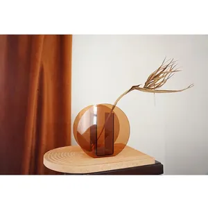 Minimalist amber acrylic circular vase with geometric design for Nordic home decor.