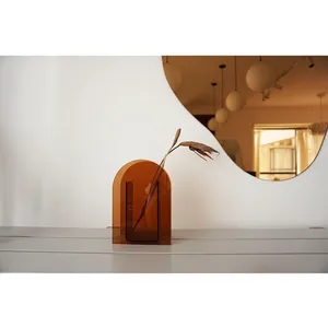 Modern amber acrylic arch-shaped vase with minimalist design for artistic home decor.