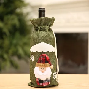 Primer plano de una funda festiva de arpillera verde para botella de vino con Papá Noel