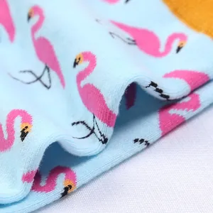Gros plan sur la texture du tricot des chaussettes bleu clair à motif flamant rose