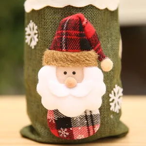 Primer plano de una funda decorativa de yute verde para botellas con Papá Noel
