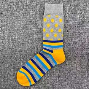 Detailansicht von Baumwoll-Herrensocken mit gelben Punkten und bunten Streifen.