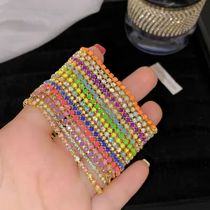 Nahaufnahme von bunten Kristallarmbändern, die von Hand vor schwarzem Hintergrund präsentiert werden