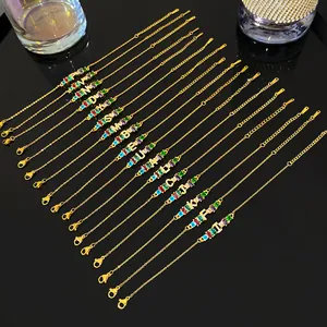 Vista detallada de pulseras en cadena dorada con piedras de colores e iniciales