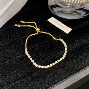 Detailansicht eines goldenen verstellbaren Armbands mit glitzernden Steinen