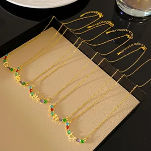 Vue détaillée de colliers dorés à lettres arc-en-ciel et cristaux multicolores