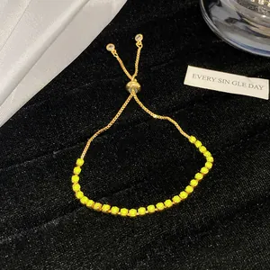 Detailansicht eines goldfarbenen Armbands mit neongelben Rosen und Zirkon-Akzenten