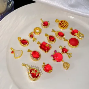 Vue détaillée de divers pendentifs en or et zircon rouge aux motifs vintage