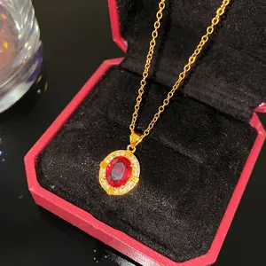 Vue détaillée d'un élégant collier en or avec pendentif rubis dans un écrin rouge