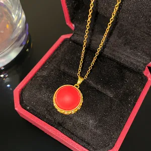 Gros plan d'un collier de style vintage avec pendentif rond rouge dans un écrin rouge