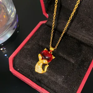Macro d'un collier en or avec pierre précieuse rouge et pendentif poisson en zircons