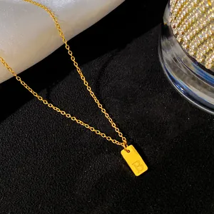 Détail du collier en acier titane doré avec un pendentif rectangulaire lettre B