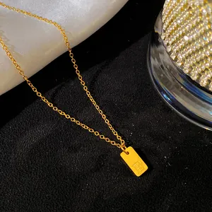 Vue détaillée de la lettre E gravée sur un pendentif en acier titane doré