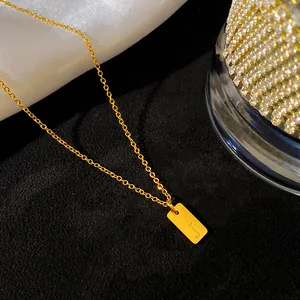 Détail d'un pendentif en acier titane doré gravé de la lettre J