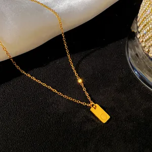 Vue détaillée d'un collier en acier inoxydable doré avec un pendentif lettre O gravé.