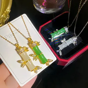 Primo piano di eleganti pendenti a forma di bambù con strass su catene dorate