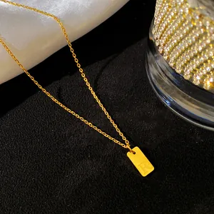 Vue détaillée d'un collier en acier titane doré avec un pendentif rectangulaire lettre R.