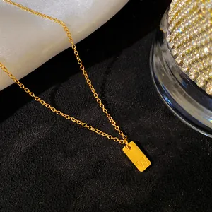 Détail d'un collier minimaliste en acier inoxydable doré avec pendentif lettre 'W'.