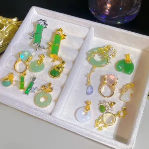 Elegant collection of imitation jade necklaces and rings in a white jewelry tray